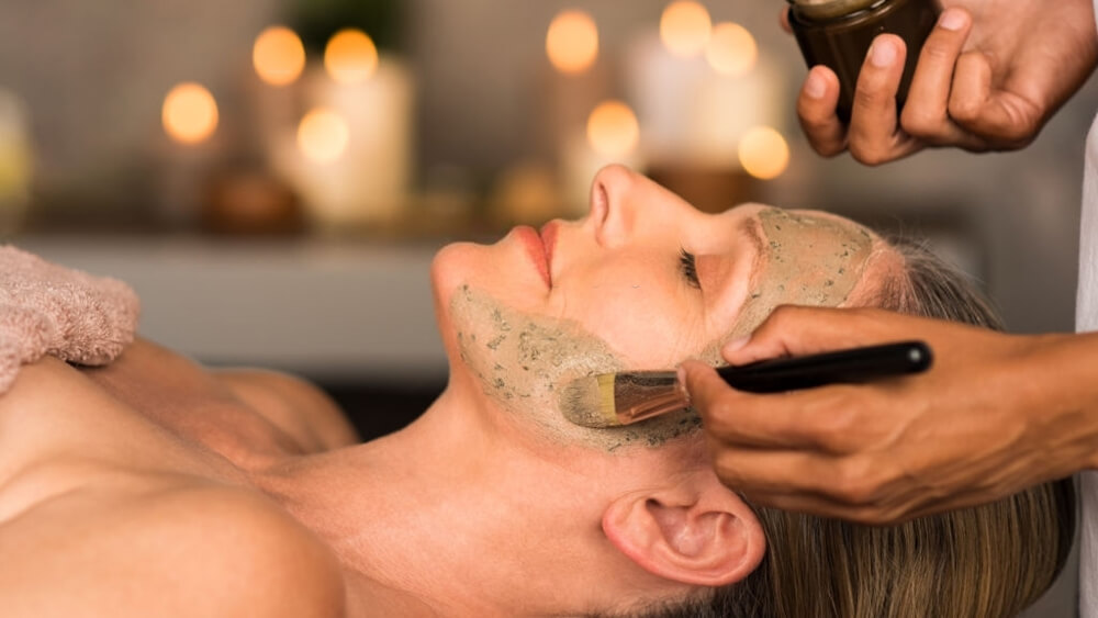 a woman with cleansing facial on her face