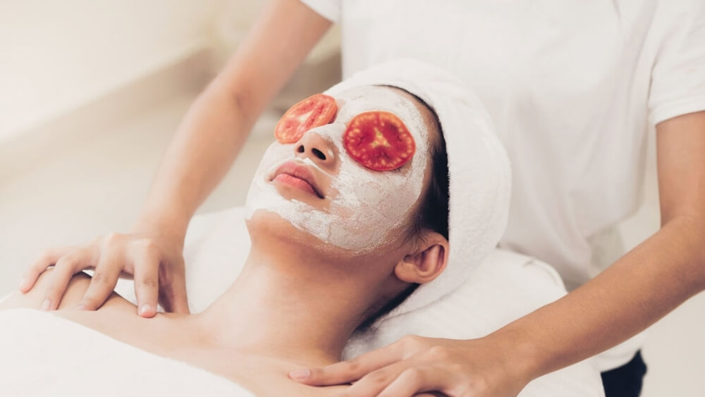 a woman get enzymatic mask with tomato cream